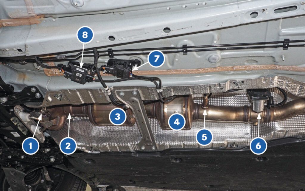 Unterboden eines VW Golf mit Blick auf den Auspuff, SCR-Katalysator, Sperrkatalysator, Partikelsensor, Steuergerät und NOx-Sensor